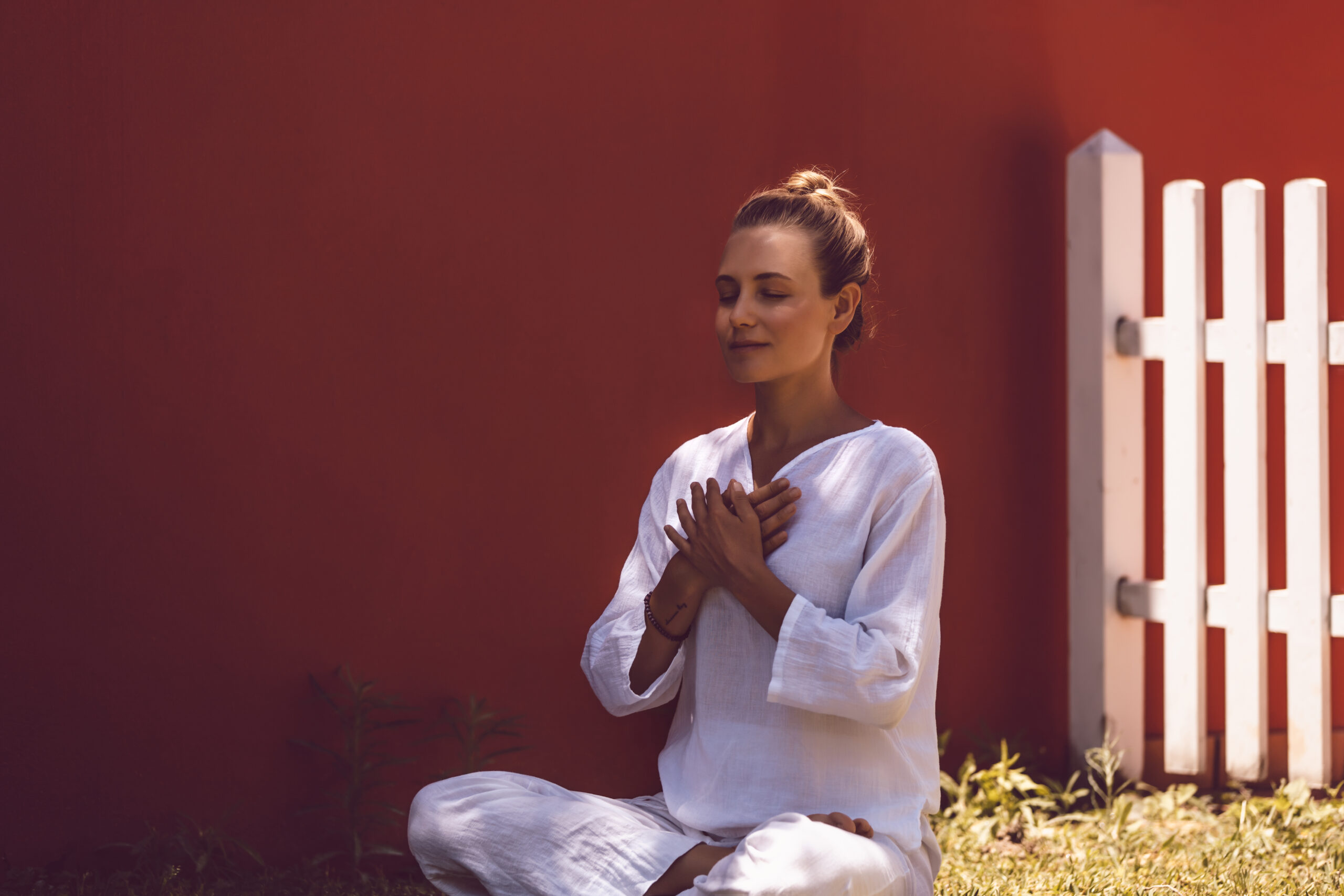 Beautiful Peaceful Female Doing Yoga Exercises in the Backyard. Morning Meditation in Lotus Posture. Healthy Zen Lifestyle